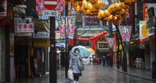 Một phụ nữ đeo khẩu trang ở khu phố Hoa tại thành phố Yokohama /// Reuters